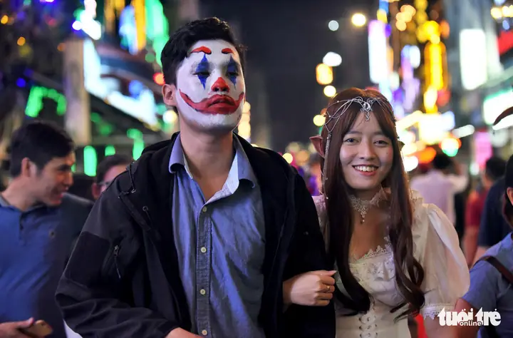 A Man Masquerades As A Clown Alongside A Woman Dressed As A Beautiful Goblin On Bui Vien Street In District 1, Ho Chi Minh City, October 31, 2019. Photo: Duyen Phan / Tuoi Tre